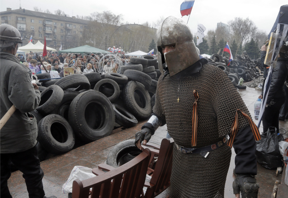 A pro-Russian activist dressed as a knight guards the barricade at the regional administration building that was seized earlier in Donetsk, Ukraine, on Thursday, as protests continued to flare up across Ukraine’s industrial heartland.