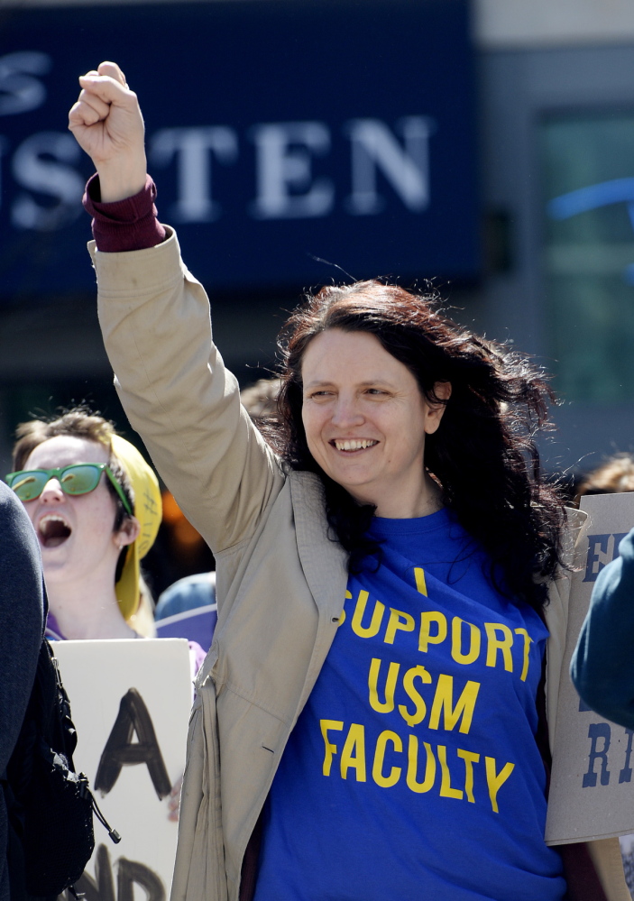 Michelle Kew, a USM graduate, shows her support for the school’s faculty during the protest in Portland on Thursday