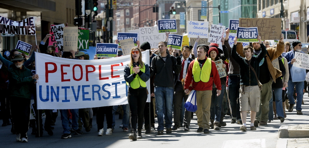 Protesters march down Congress Street to protest the budget cuts at the University of Southern Maine.