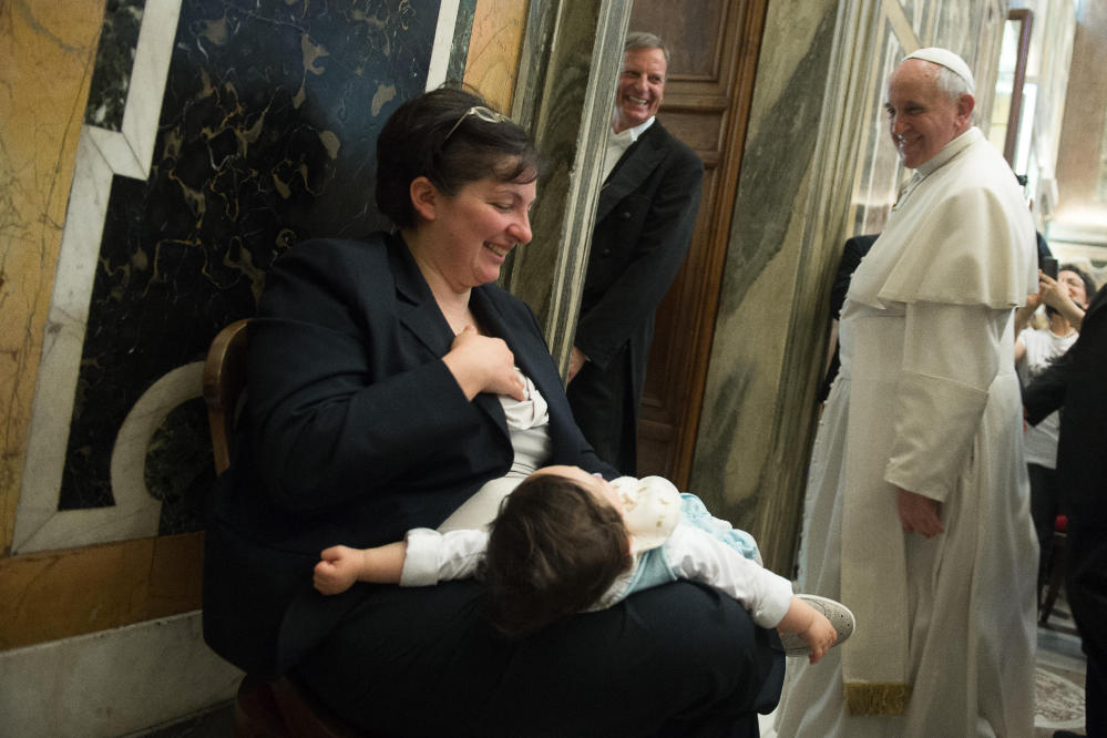 Pope Francis smiles at a woman holding her child after a meeting with an Italian pro-life movement at the Vatican on Friday.