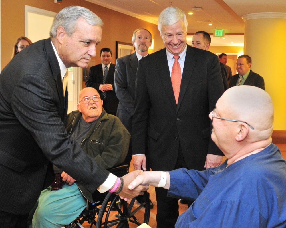 U.S. Rep. Jeff Miller, R-Fla., left, shakes hands with Bruce Pray of Winthrop during a tour Friday of the VA hospital at Togus, as U.S. Rep. Mike Michaud, D-Maine, looks on.