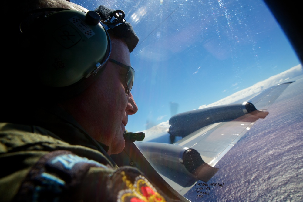 Sgt. Trent Wyatt, a crew member of a Royal New Zealand Air Force P-3 Orion, is tasked with visually searching for aircraft debris as the plane flies at 800 feet on Friday.