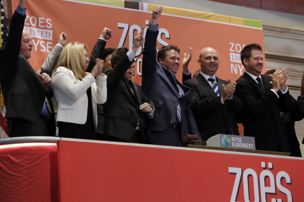 Zoe’s Kitchen President and CEO Kevin Miles, center, celebrates as he rings the New York Stock Exchange opening bell, marking his company’s IPO on Friday.