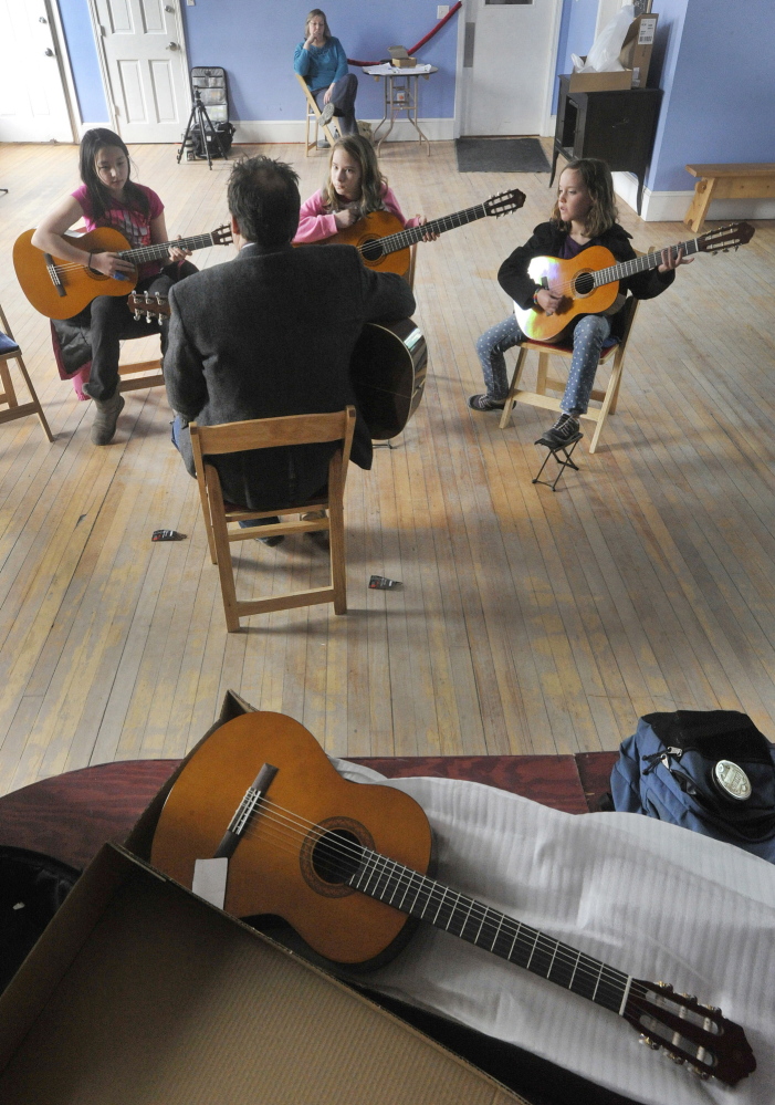 Guitar teacher Don Pride works with students at Mayo Street Arts, which is teaming with the Portland Conservatory of Music to bring music education to students in the Bayside area of Portland.