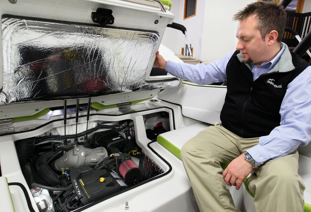 Jeremy Moore of SkipperBud’s looks over the jet drive engine on a Scarab 195 impulse. Boats that use a jet drive instead of a propeller are becoming more popular, the boat dealer says.