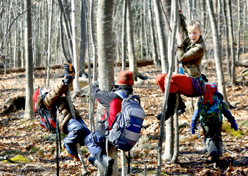 “Squirrel Scurry” is the game, led by Annika Wisswaesser, right, as Bruno Pincero, left, and Iver Myles follow by clinging to trees and lifting their legs on an expedition through a wooded area of coastal Cape Neddick in York County.