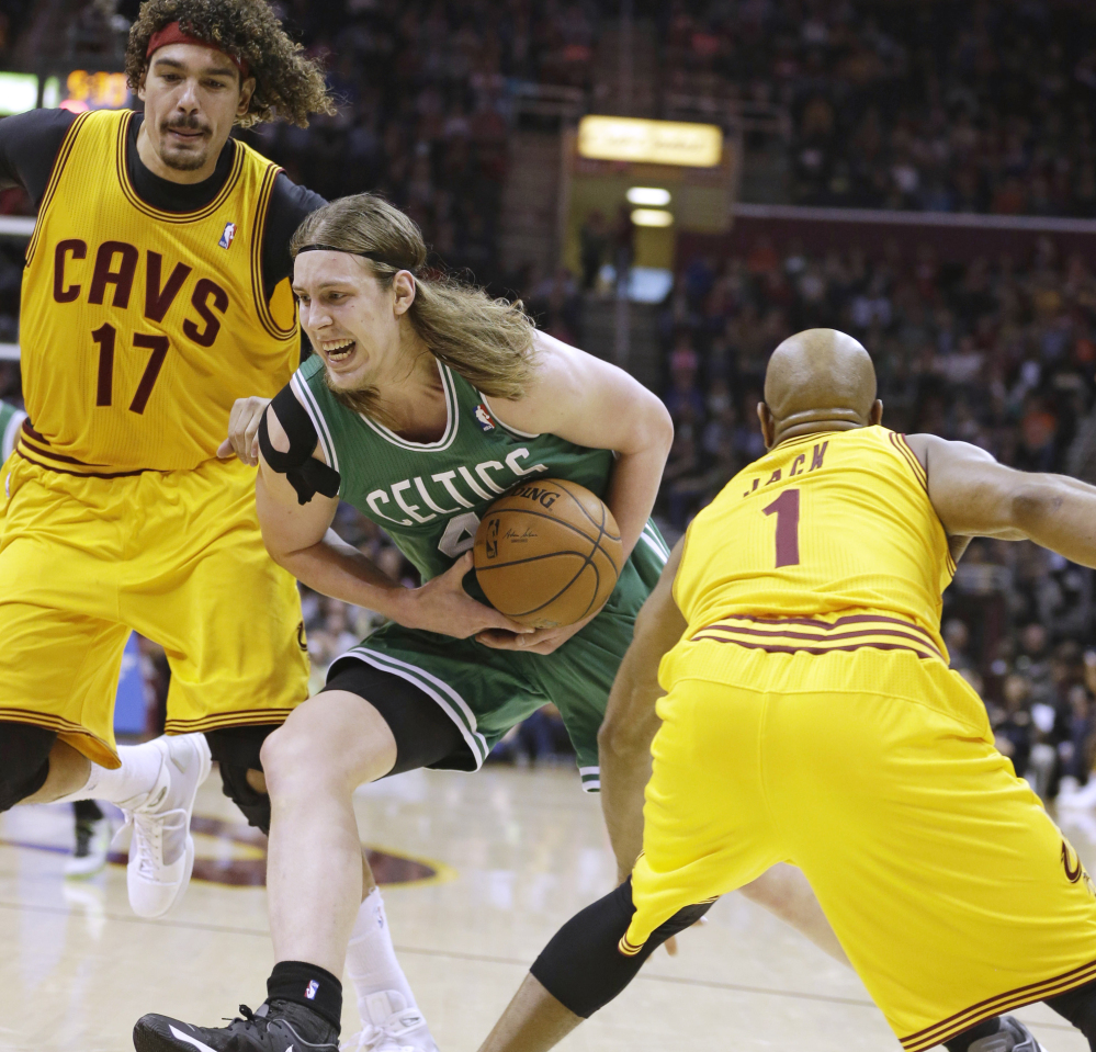 Boston’s Kelly Olynyk tries to keep a handle on the ball as he drives between Cleveland’s Anderson Varejao, left, and Jarrett Jack during the Celtics’ win Saturday at Cleveland.