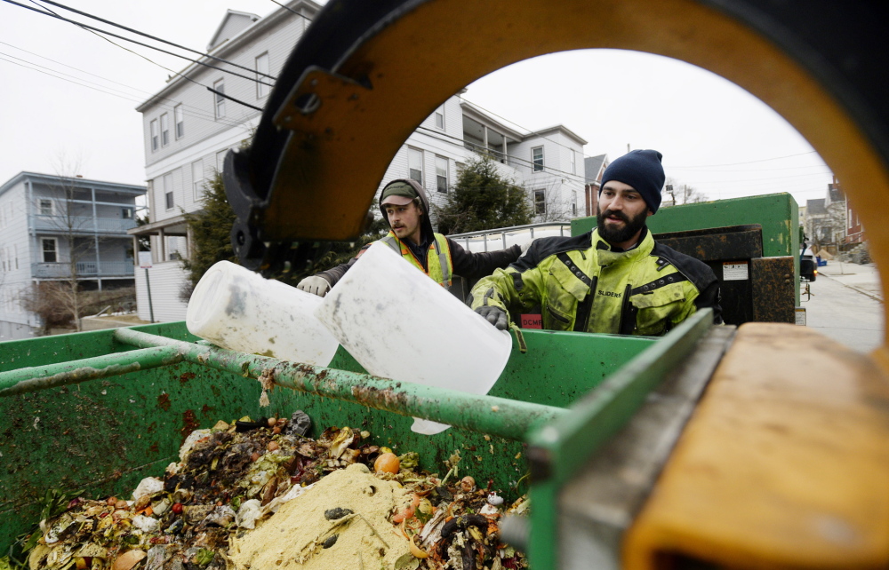 Lee Michael, left, and Cory Fletcher of Garbage to Garden pick up kitchen scraps during their rounds in Portland late last month. The waste will be composted.