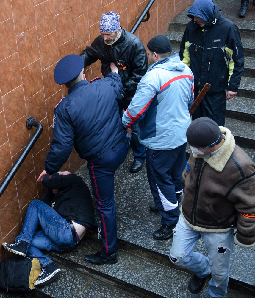 A police officer stops a pro-Russian activist who is charging toward a Ukrainian protester lying on the steps in Kharkiv on Sunday. But police have often proven unable or unwilling to repel pro-Russian gunmen and Moscow loyalists.