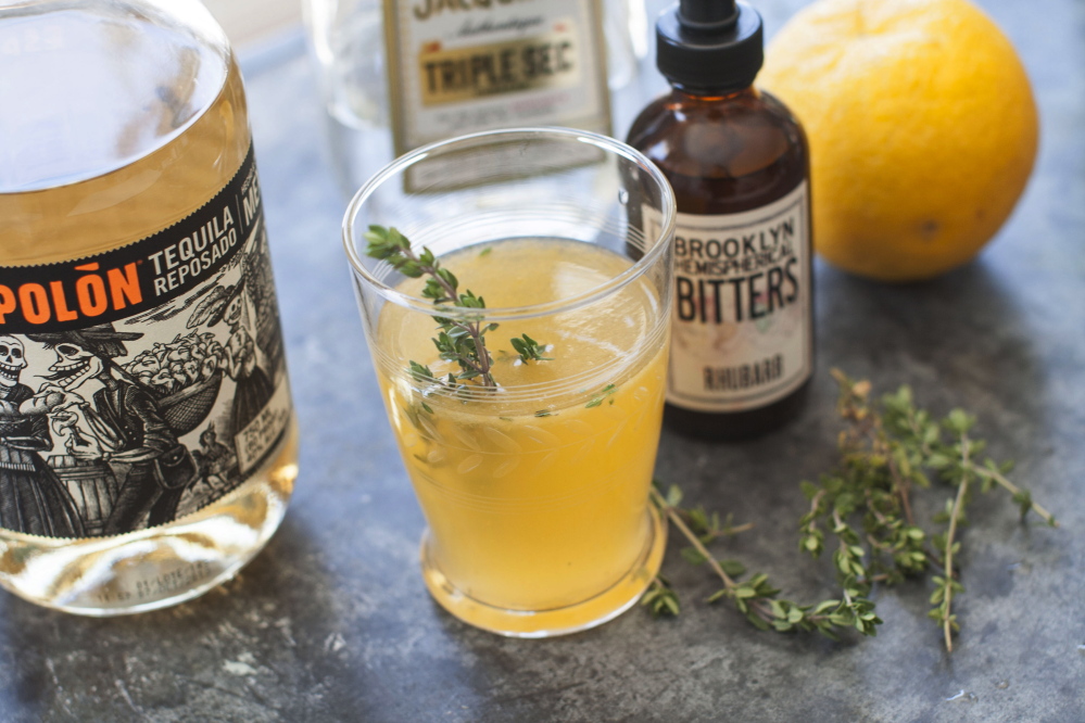 A Summer Rain, made with rhubarb bitters, tequila and orange liqueur, is topped off with a sprig of fresh thyme.
