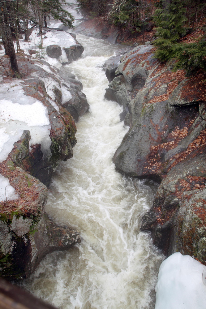 Water from melting snow and rain flow down the Cockermouth River through Sculpture Rocks in Groton, N.H., on Tuesday. Concerns about flooding in northern New England grew Tuesday as more rain comes to the region.