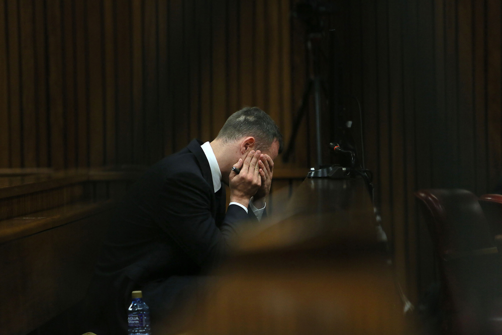 Oscar Pistorius holds his hands to his face as he listens to evidence being given in court in Pretoria, South Africa, Tuesday, after questioning by state prosecutor Gerrie Nel, had earlier finished.