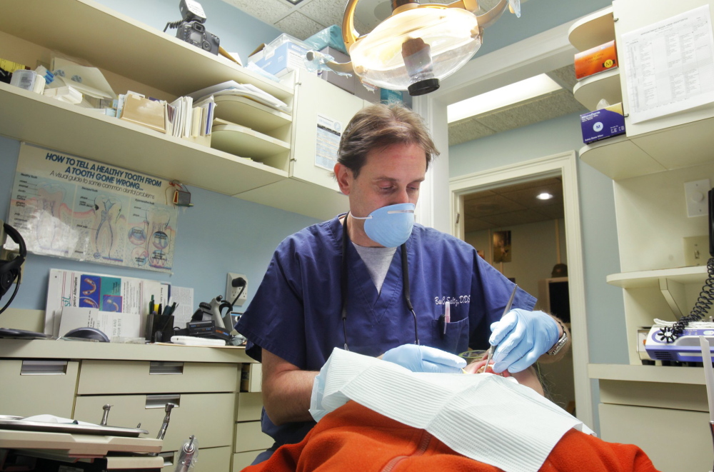 Dr. Barry Saltz works with a patient in his dental office. In the fields of dentistry and psychology, two-thirds of current Maine practitioners are older than 50, according to the Department of Labor’s Center for Workforce Research and Information.