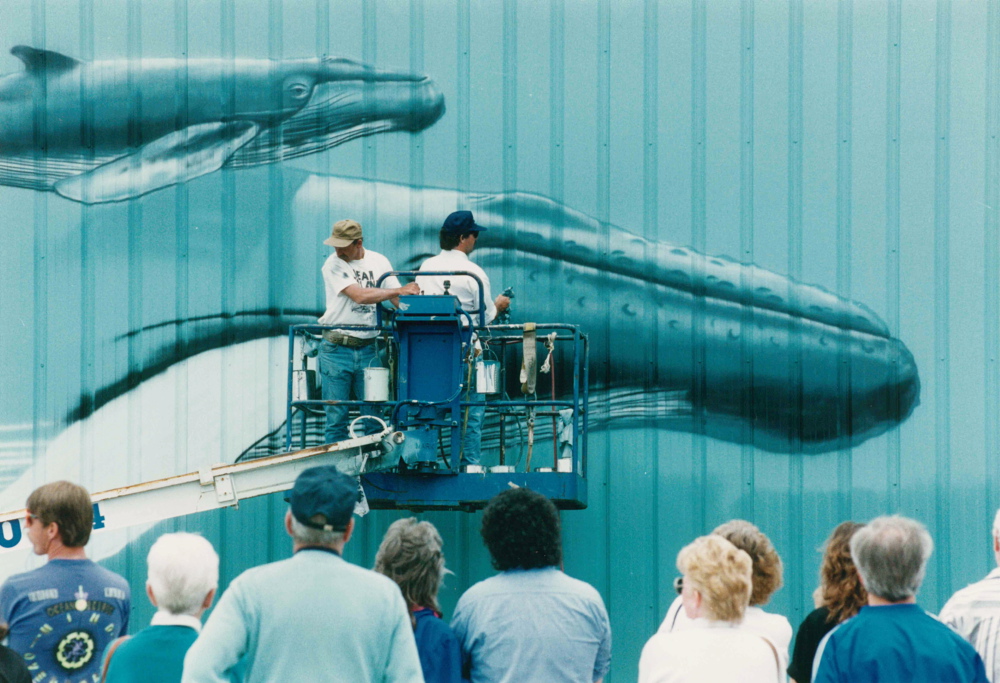 Artist Robert Wyland, known simply as Wyland, and an assistant work on the whale mural at the Maine State Pier in Portland in June 1993. The local artwork was the first of 17 marine-themed murals the artist created in 17 East Coast cities that year