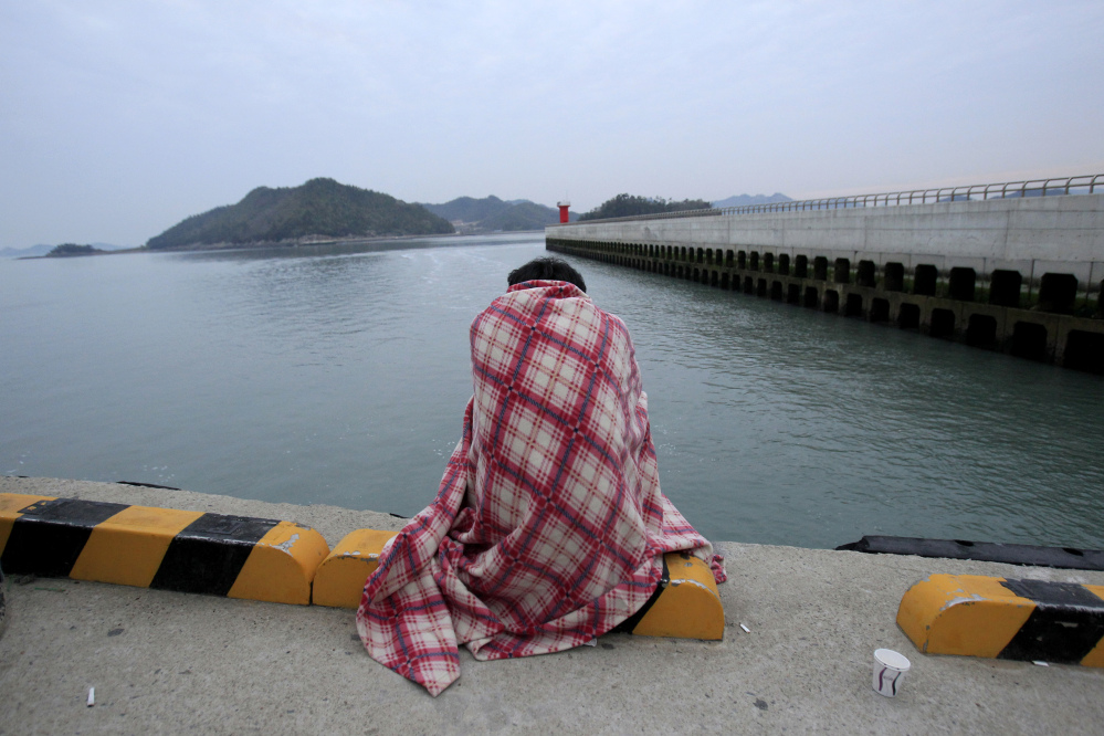 A relative waits for their missing loved one at a port in Jindo, South Korea, Wednesday, April 16, 2014. A ferry carrying 459 people, mostly high school students on an overnight trip to a tourist island, sank off South Korea’s southern coast on Wednesday, leaving nearly 300 people missing despite a frantic, hours-long rescue by dozens of ships and helicopters.
