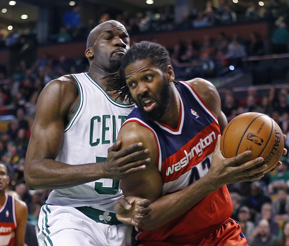 Wizards forward Nene Hilario drives against Boston center Joel Anthony in Wednesday night’s game at Boston. The Wizards won to clinch the fifth playoff seed in the Eastern Conference.
