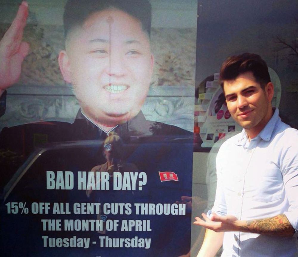 At M&M Hair Academy in South Ealing, London, barber Karim Nabbach stands next to a poster poking fun at North Korean leader Kim Jong Un’s hairstyle.