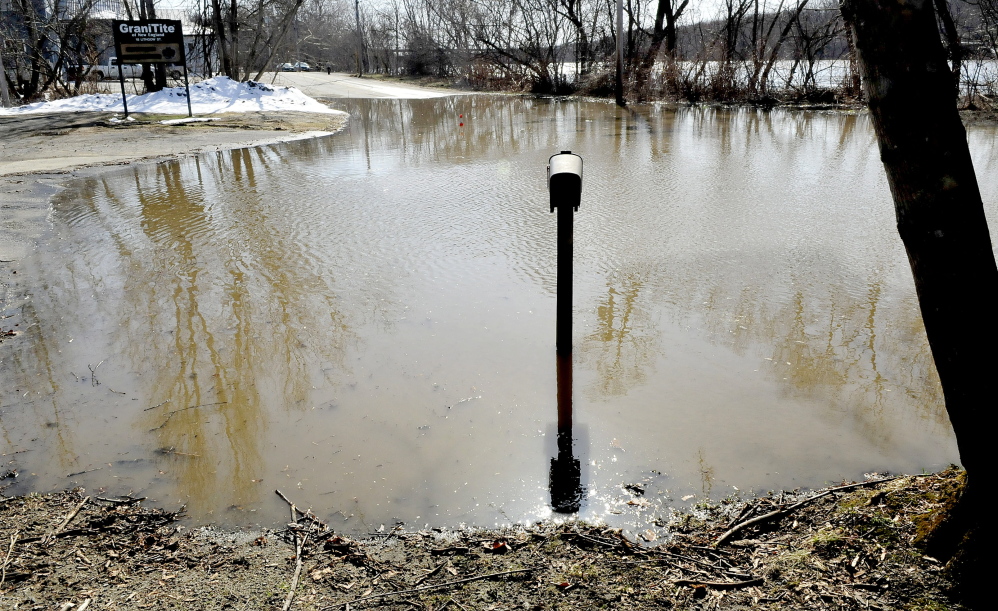 A mailbox and post are surrounded by water from the Kennebec River that overflowed on Lithgow Street in Winslow forcing officials to close the road on Wednesday, April 16, 2014. The road closure is near where seven homes were washed down the river during the flood in 1987.