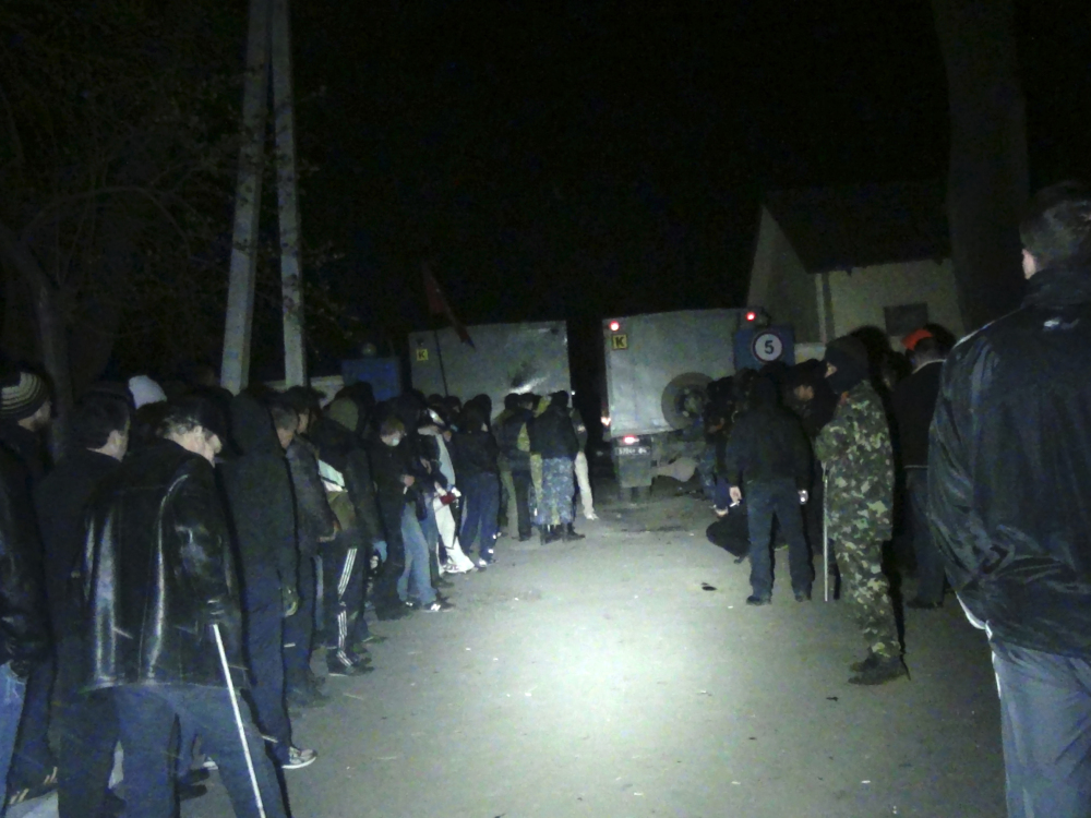 Unarmed pro-Russian militants line up at the gates to the National Guard base, blocked by trucks in Mariupol, early Thursday. Three pro-Russian militants died and 13 were wounded when Ukrainian troops repelled an attack on the National Guard base in the Black Sea port of Mariupol.