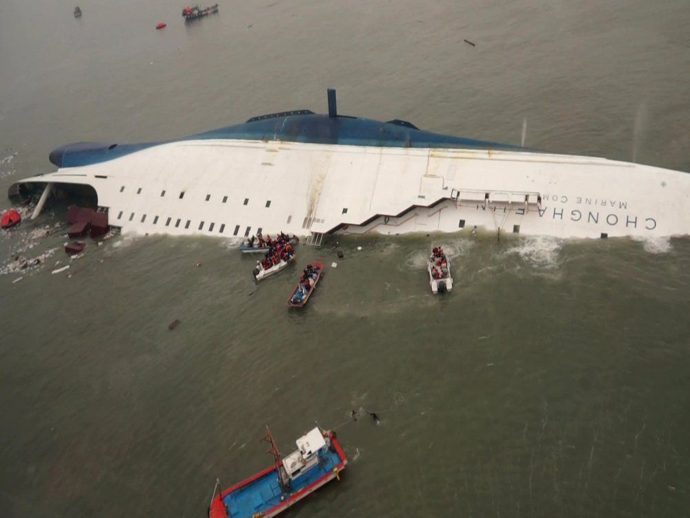 In this photo released by South Korea Coast Guard via Yonhap News Agency, South Korean rescue team boats and fishing boats try to rescue passengers of a ferry sinking off South Korea’s southern coast.
