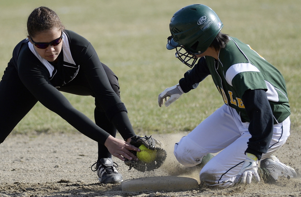 Kim Fisher of McAuley steals second base, sliding in ahead of a late tag applied by Kaylah Abdul of Marshwood during their season-opening softball game Thursday in Portland. Marshwood won in 13 innings, 7-5.