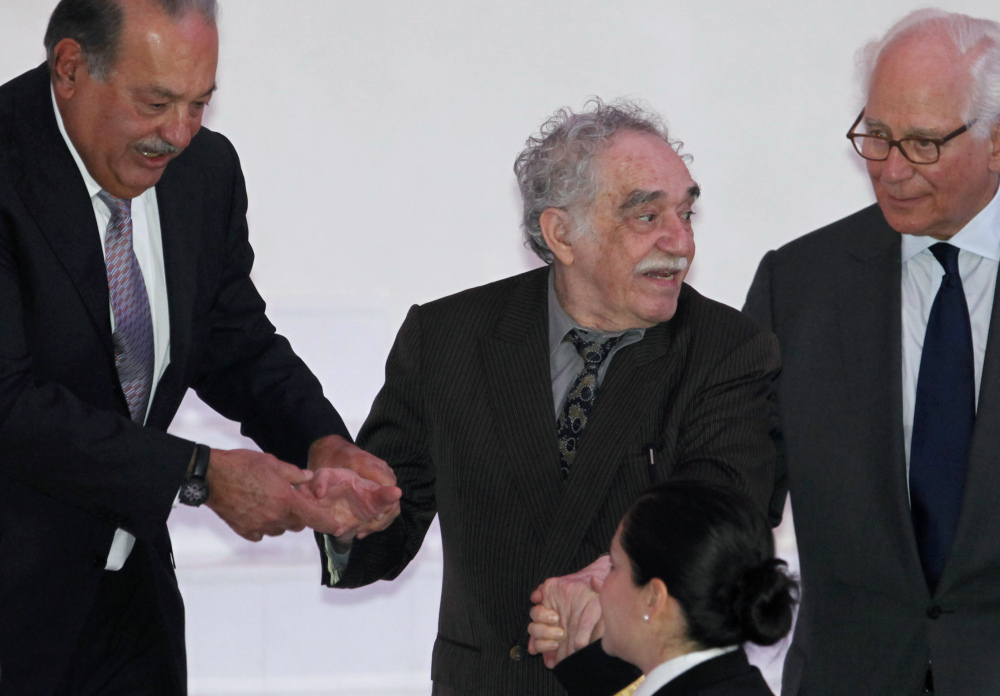 In this March 2011 file photo, Mexican telecom tycoon and world’s richest man Carlos Slim, left, and British financier Sir Evelyn de Rothschild, right, help Nobel laureate Gabriel Garcia Marquez at the inauguration of the Soumaya Museum’s new home in Mexico City. Marquez died Thursday April 17, 2014 at his home in Mexico City.