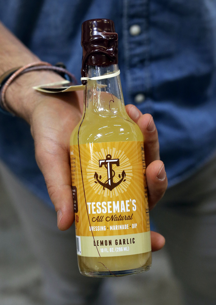 A bottle of Tessemae’s lemon garlic dressing is displayed by the CEO Greg Vetter in the company’s offices in Essex, Md.
