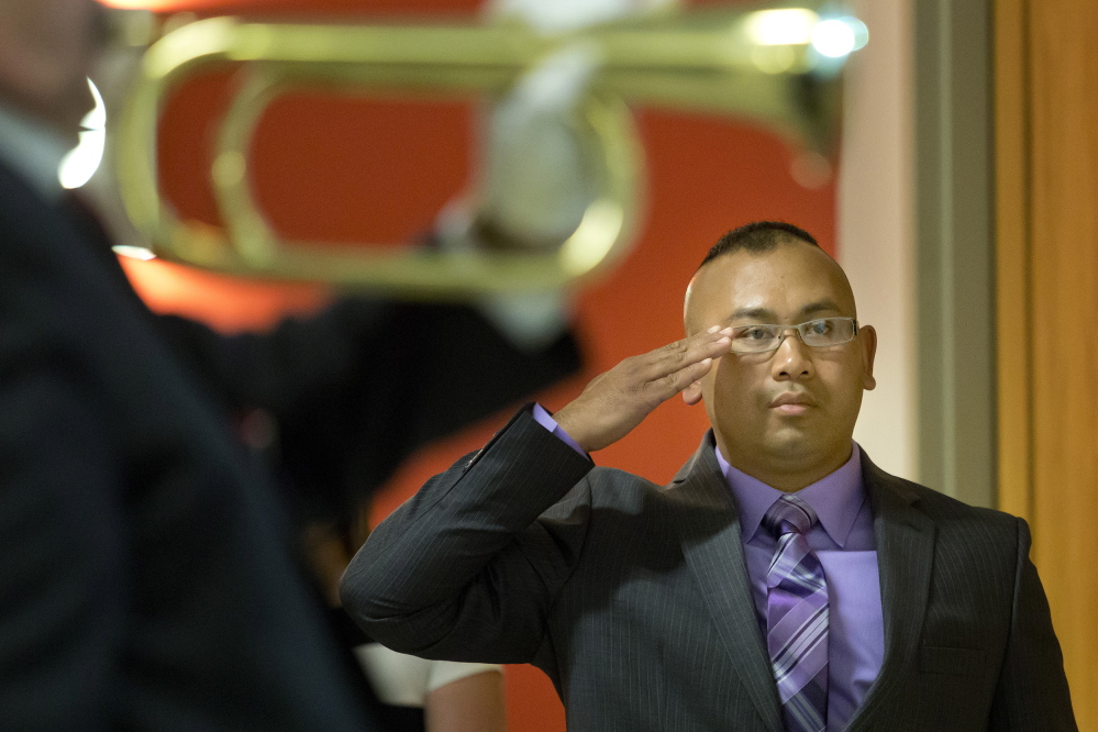 Retired Army Staff Sgt. San Pao stands at attention for the playing of taps during a service to honor Spc. Chris Gelineau, who was killed in combat in Iraq 10 years ago while serving with the Maine Army National Guard’s 133rd Engineer Battalion.