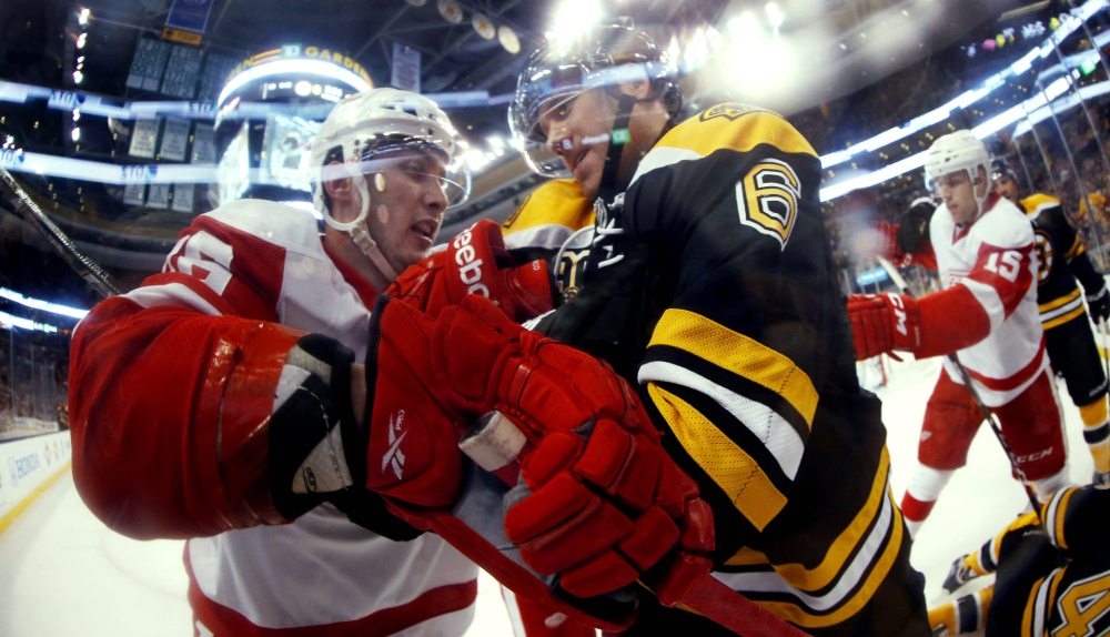 In this photo taken with a fish eye lens, Boston Bruins defenseman Corey Potter (6) struggles with Detroit Red Wings’ Riley Sheahan during the first period of a first-round NHL playoff hockey game in Boston on Friday, April 18, 2014.