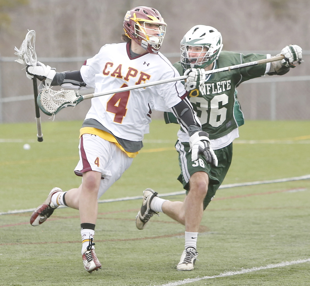 Ben Shea of Cape Elizabeth runs with the ball as Graham Chance of Waynflete attempts to knock it away Friday during Cape Elizabeth’s 15-1 victory at home in a Western Maine Conference opener.