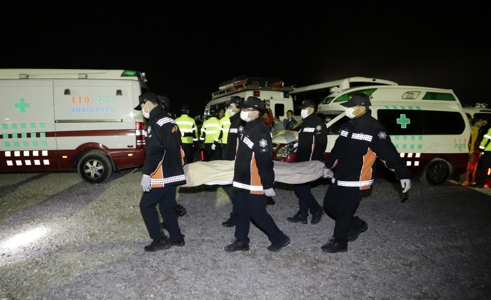 The body of a passenger aboard the Sewol ferry which sank in the water off the southern coast, is carried by rescue workers upon its arrival at a port in Jindo, south of Seoul, South Korea, Saturday.