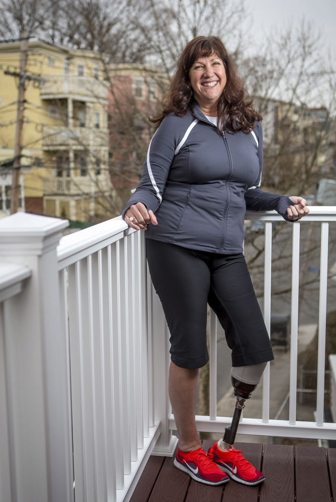 Karen McWatters poses for a portrait at her home in Somerville, Mass. Being injured in the Boston Marathon bombings last year has led to many changes in her life. She and her husband have purchased a Portland condo adapted for her needs, and the couple is helping a teen who lost a leg in an accident. McWatters misses pre-bombing anonymity, but feels that with her visibility as a survivor comes power to help others.