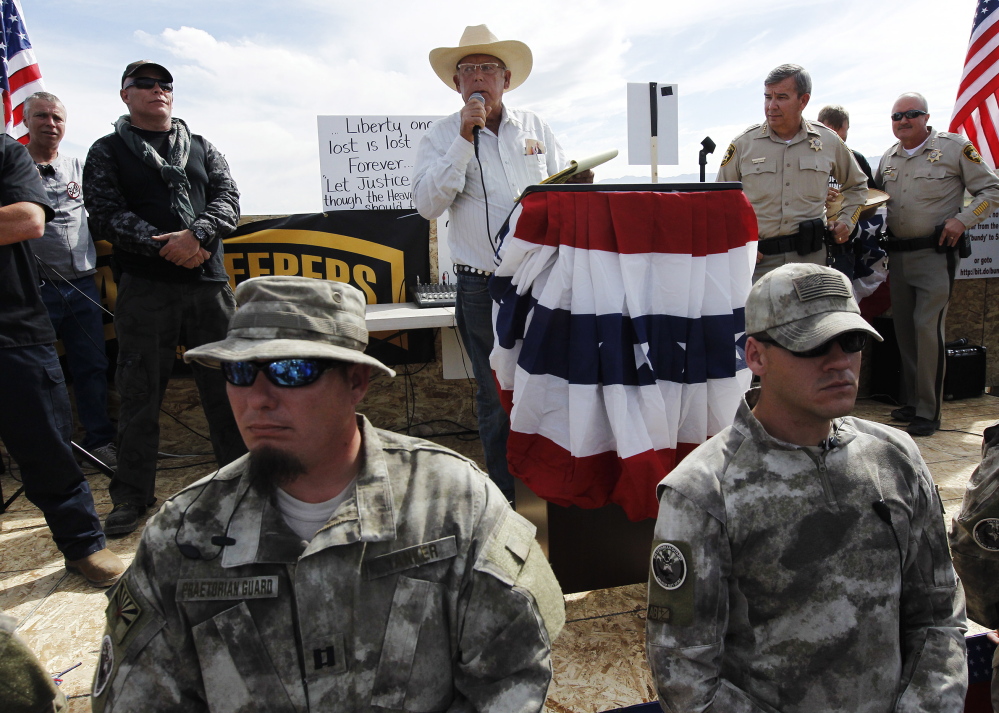 Rancher Cliven Bundy, center, addresses his supporters alongside Clark County Sheriff Doug Gillespie, right, on April 12, saying the BLM had agreed to cease the roundup of his family’s cattle.