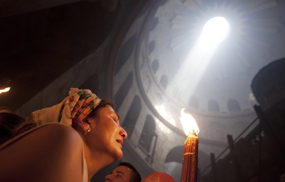 A Christian pilgrim holds candles at the church of the Holy Sepulcher, traditionally believed to be the burial site of Jesus Christ, during the ceremony of the Holy Fire in Jerusalem’s Old City Saturday.