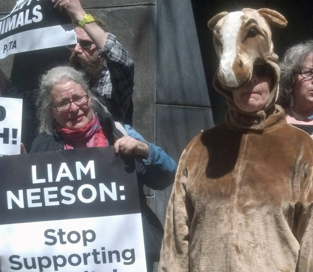 Activists picket outside the home of actor Liam Neeson Saturday in New York.