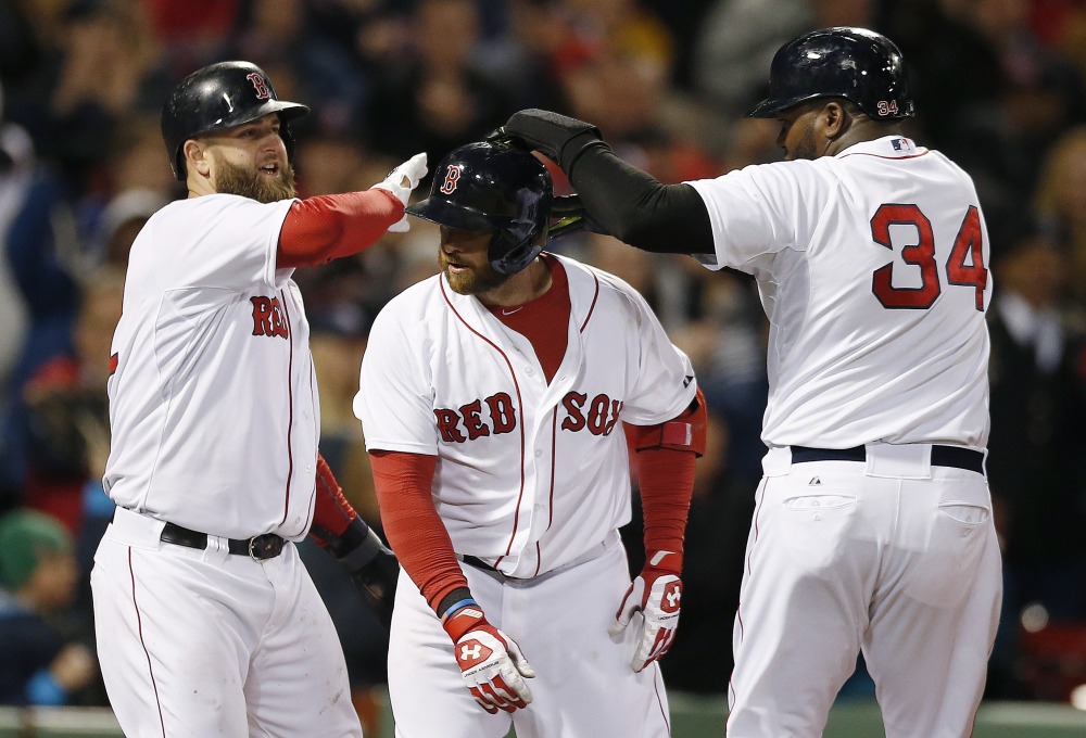 David Ortiz, right, and Mike Napoli, left, of the Red Sox celebrate after scoring a on a three-run homer by Jonny Gomes, center, in the sixth inning of Sunday’s game against the Orioles. Gomes’ shot started Boston’s comeback from a 5-0 deficit.