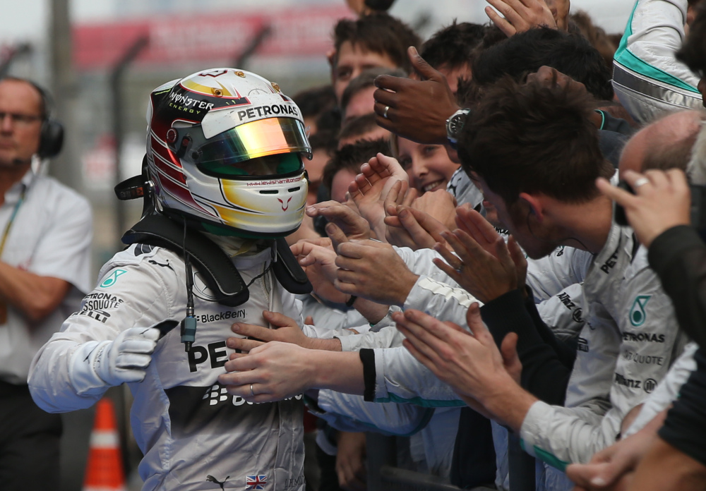 Mercedes driver Lewis Hamilton of Britain, left, is congratulated by his team members after the Chinese Formula One Grand Prix at Shanghai International Circuit in Shanghai on Sunday.
