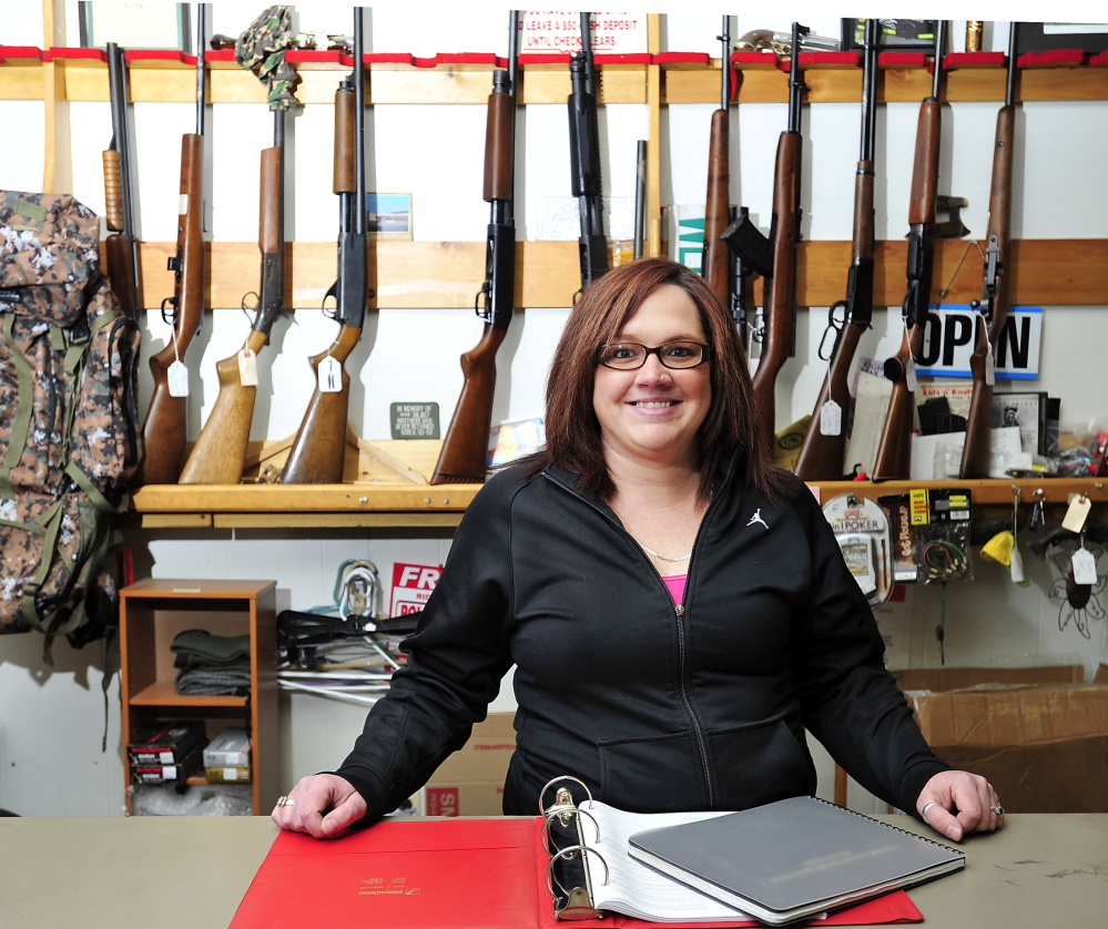 Ashley Preble, manager of Webster’s Trading Co. in Auburn, stands behind the gun counter with registrations of buyers she says are confidential to the public but open to any federal agent who wants to see the records.