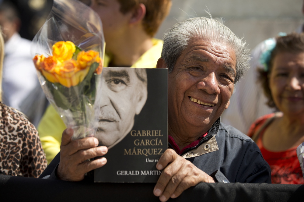 A well-wisher holds an autobiography of Colombian Nobel laureate Gabriel Garcia Marquez as he waits outside the Palace of Fine Arts in Mexico City on Monday.