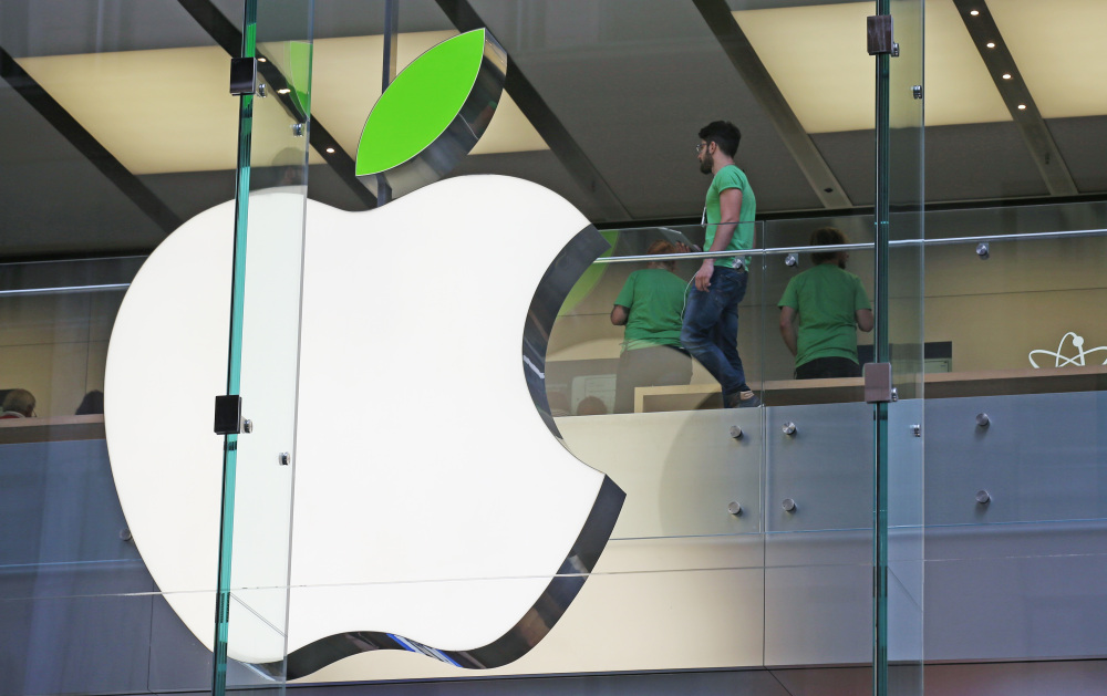 An Apple logo sports a green leaf at an Apple Store in Sydney, Australia, on Tuesday. Apple is offering free recycling of all its used products and vowing to power all of its stores, offices and data centers with renewable energy to reduce the pollution.