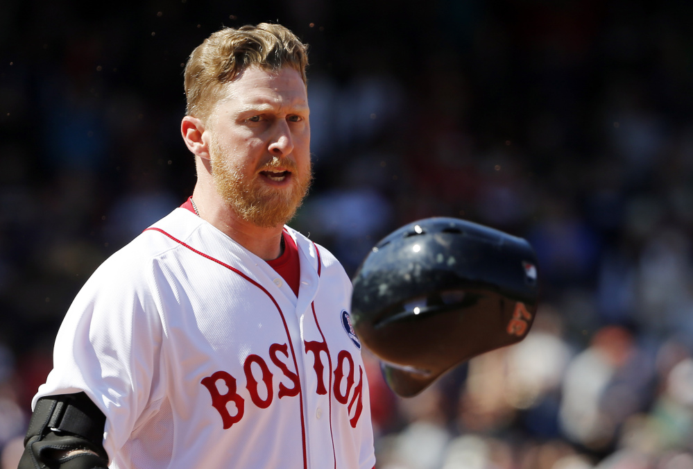 Boston’s Mike Carp tosses his helmet in frustration after his ninth-inning groundout with two runners on sealed a 7-6 loss to Baltimore at Fenway Park on Monday