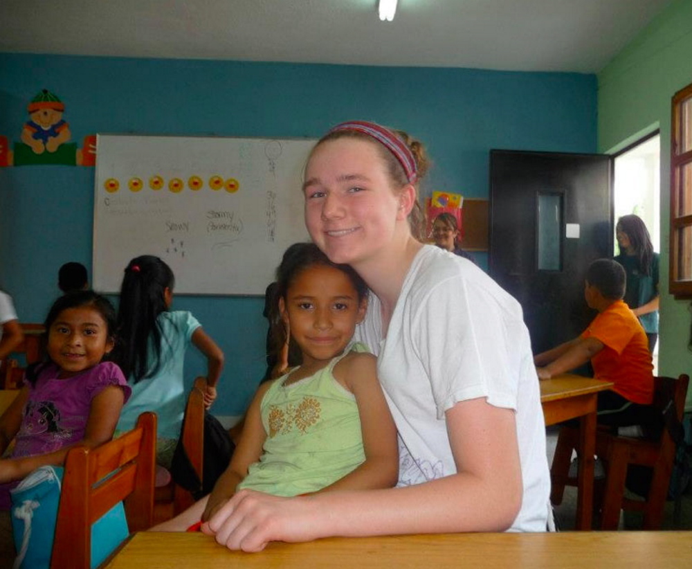 Caroline Maker poses with a student at Safe Passage in Guatemala while visiting her older sister, who was volunteering there in April 2013. Caroline, 15, organized a group of fellow sophomores from Greely High School to spend their spring break volunteering at the program.