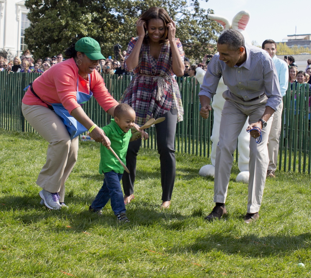 President Obama and first lady Michelle Obama cheer a child as they host the White House Easter Egg Roll on the South Lawn of the White House in Washington on Monday.