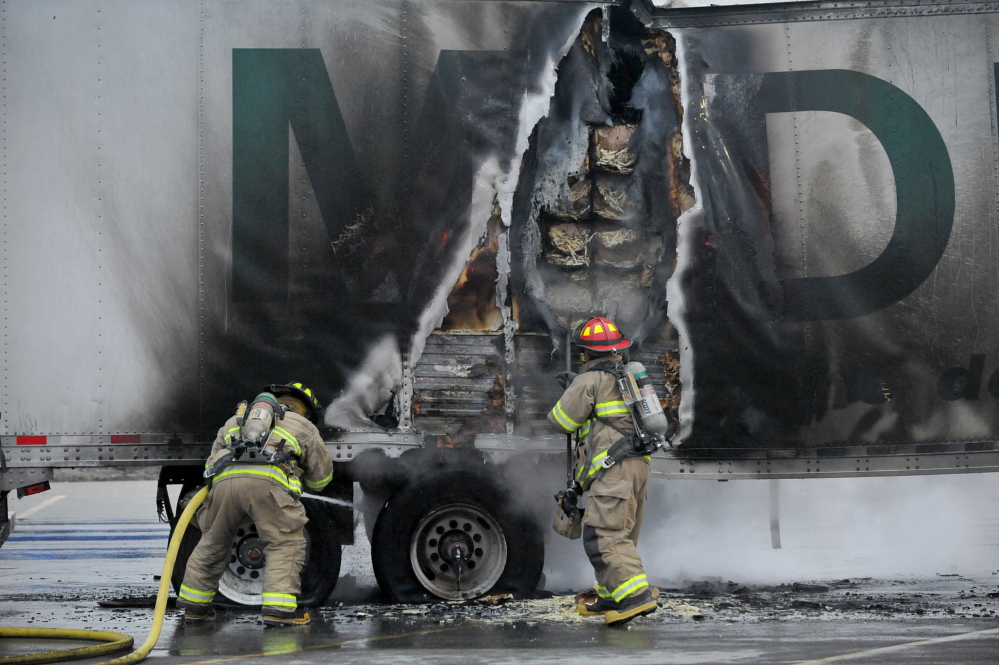 Firefighters from the Waterville Fire Department extinguish a fire in a truck’s trailer full of french fries in the Walmart parking lot in Waterville Tuesday evening.