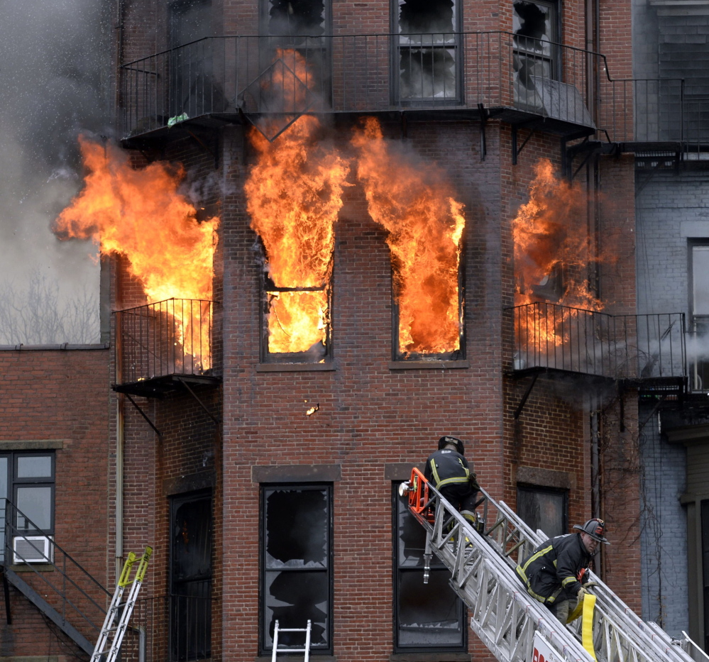 Boston firefighters work a multi-alarm brownstone fire on March 26. Two firefighters died in the wind-driven blaze that ripped through the brownstone.