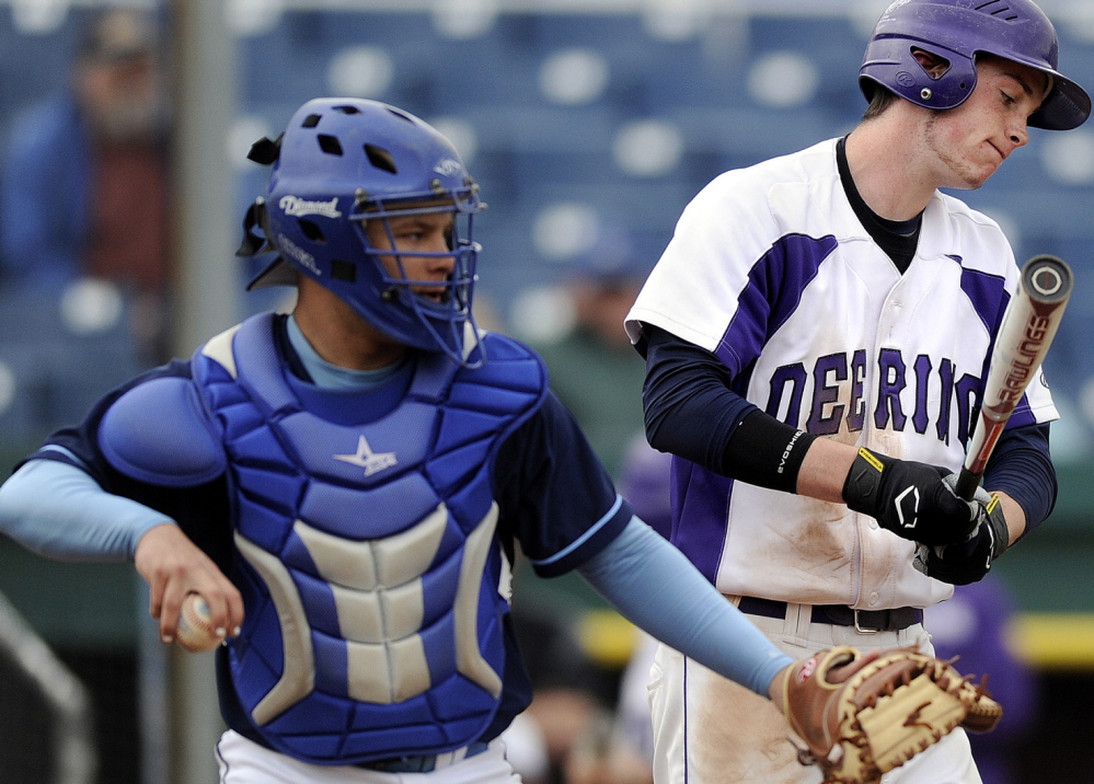 Westbrook catcher Kyle Heath prepares to throw the ball around the horn as Nick Carmichael of Deering reacts after striking out at Hadlock Field. Westbrook is seeking a second straight state title and Deering is attempting to work its way back into contention.