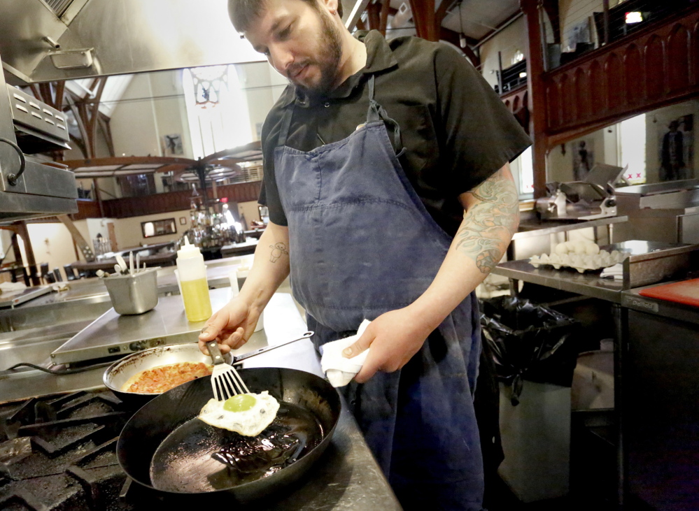 Executive chef Pete Sueltenfuss of Grace in Portland fries a duck egg to top a pizza.