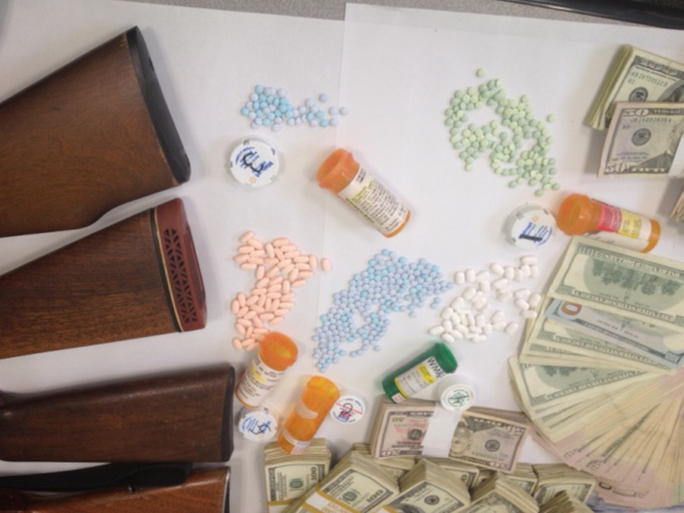 Weapons, pills and cash seized in an Avon drug bust are displayed at the Franklin County Sheriff’s Office on Tuesday.