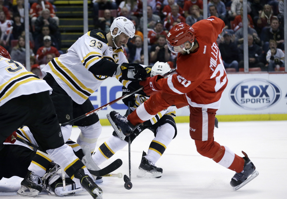 Boston Bruins defenseman Zdeno Chara (33) of the Czech Republic and Detroit Red Wings left wing Drew Miller (20) battle for the puck during the second period.