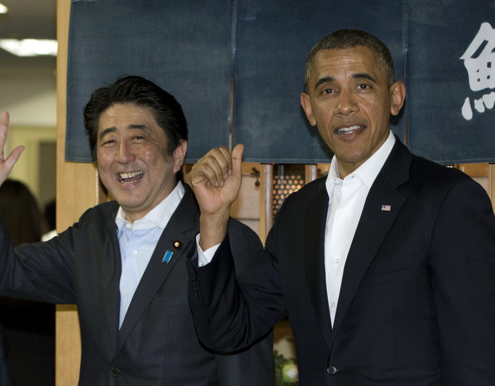 President Obama and Japanese Prime Minister Shinzo Abe leave a sushi restaurant in Tokyo Wednesday.